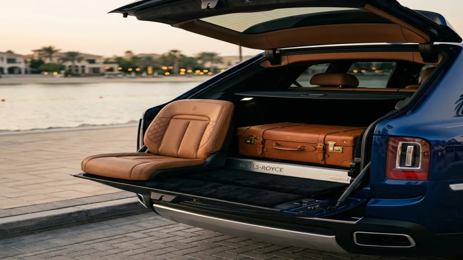 The rear cargo viewing suite of a Rolls-Royce Cullinan parked at the desert edge in Dubai at sunset
