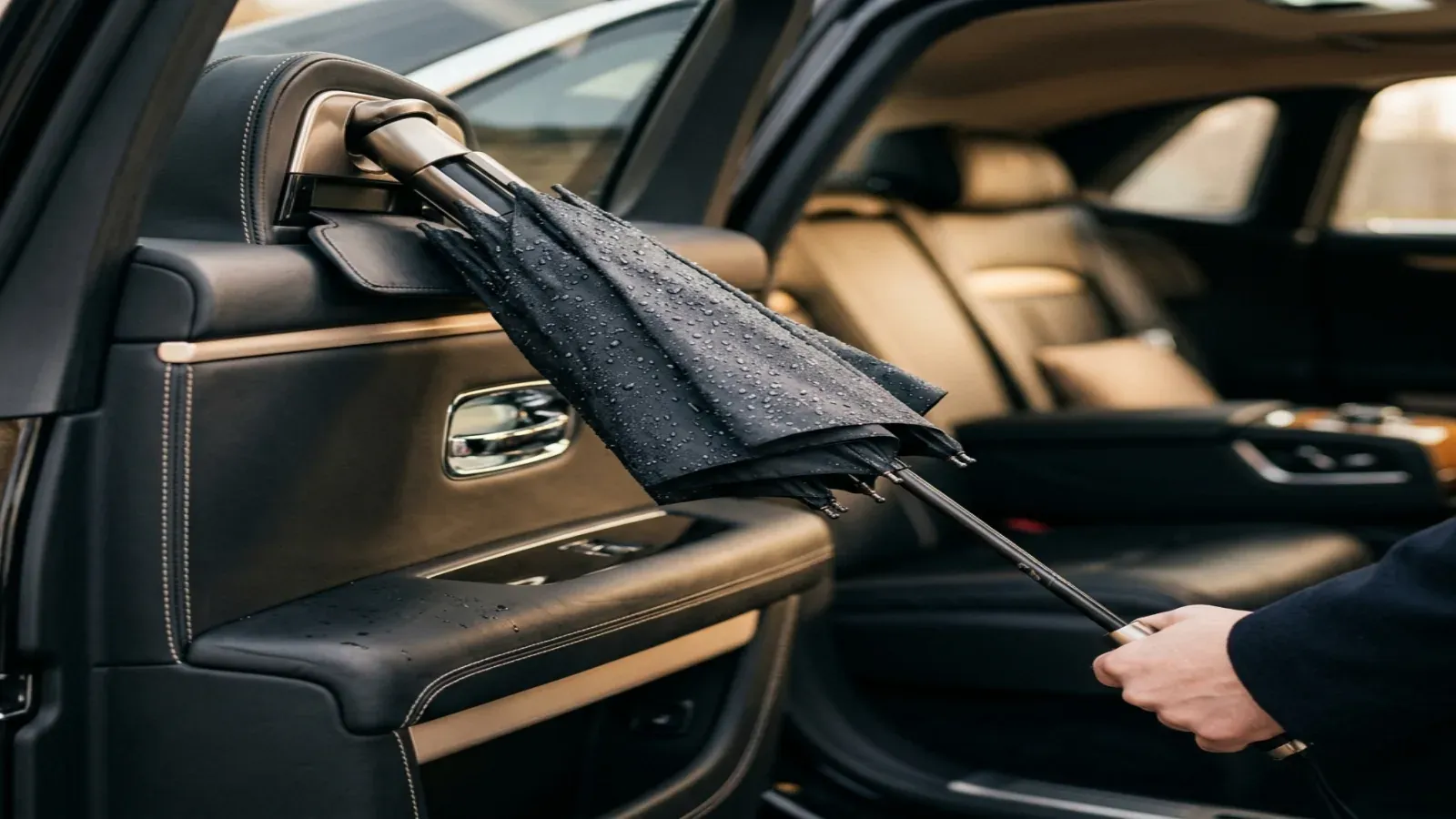 A luxury Rolls-Royce Cullinan parked in front of a modern Dubai skyscraper