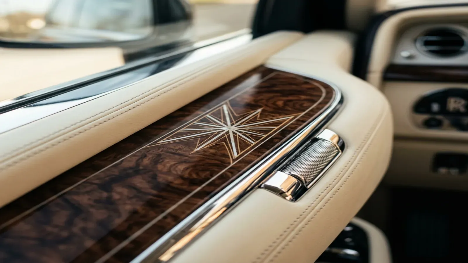 A close-up of a Rolls-Royce steering wheel and hand-stitched leather dashboard